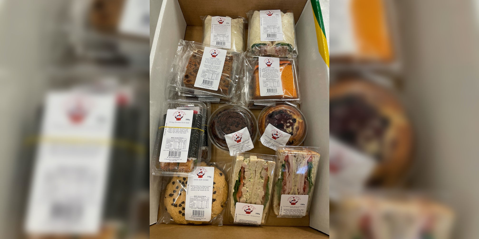 assorted-fresh-meals-baked-goods-choc-chip-cookie-sandwich-fruit-cake-orange-cake-slice-pita-wrap-double-choc-chip-muffin-blueberry-muffin-prepacked-labelled-barcoded-retail-ready